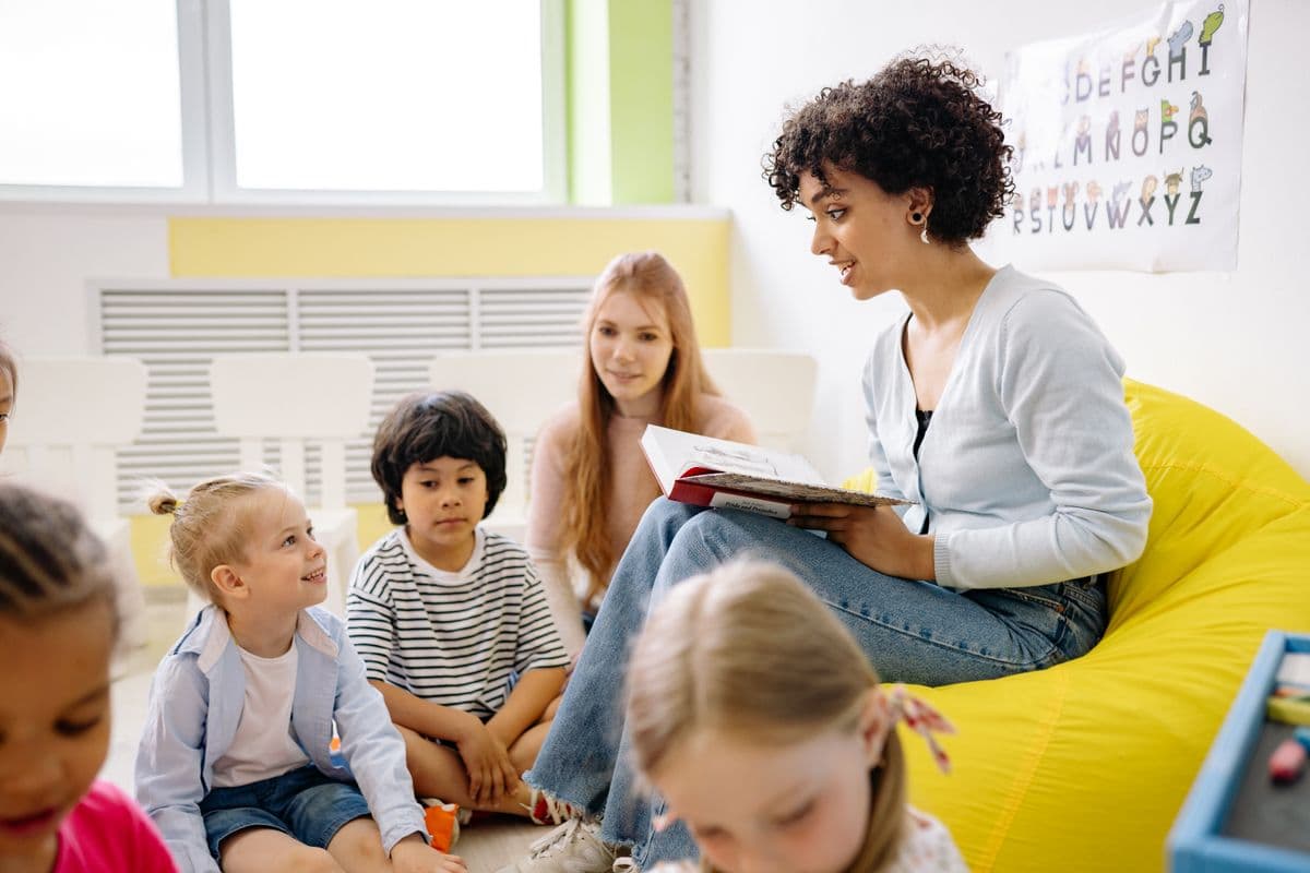 Teacher reading with elementary students in a bright classroom