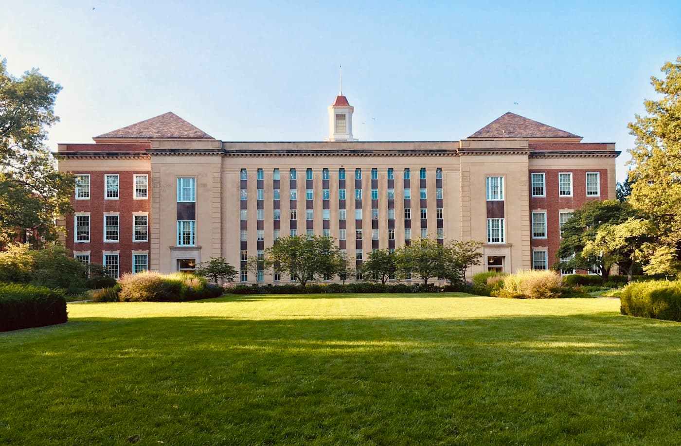 Brick school building across a green quad